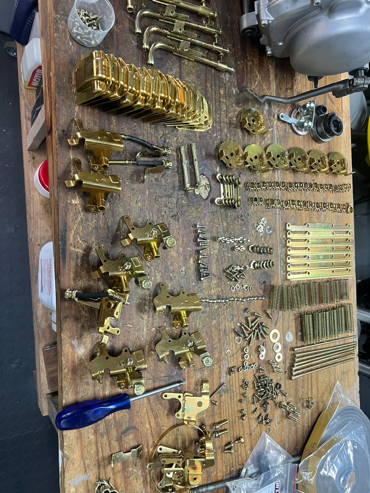 Zinc-plated fasteners and brackets laid out on the workbench